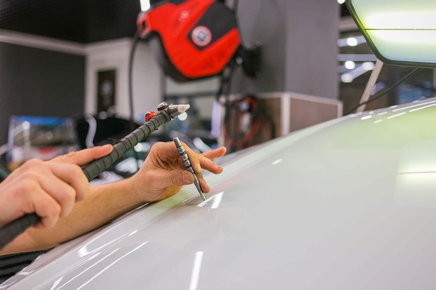 Technician performing paintless dent repair on car roof after hail damage in Montrose, CO